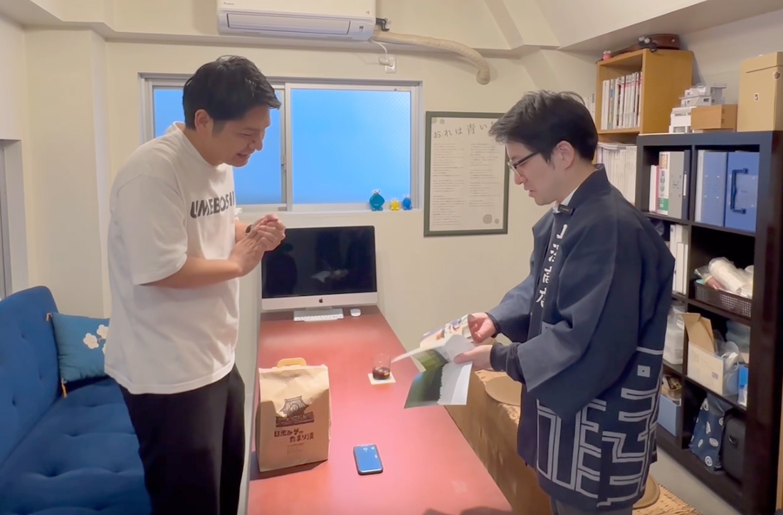 竹内さんにカタログを渡す上澤